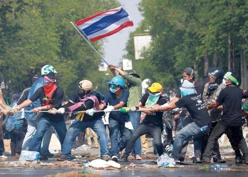 2日，在泰国首都曼谷的政府大厦附近，抗议者用绳子拉开警方设置的路障。